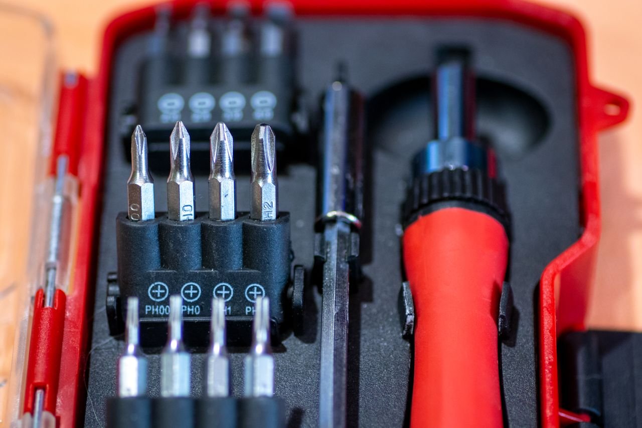 Home Detailed view of a screwdriver set in a red case, featuring interchangeable bits and tools.